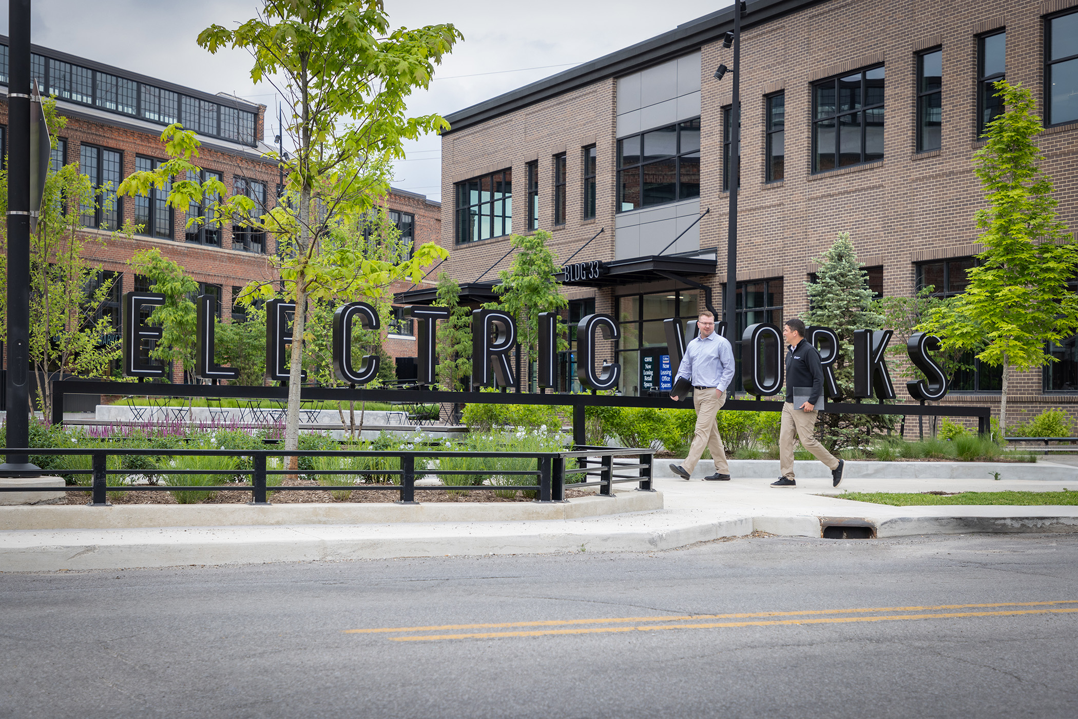 Garmann Miller team members walking in front of Electric Works sign