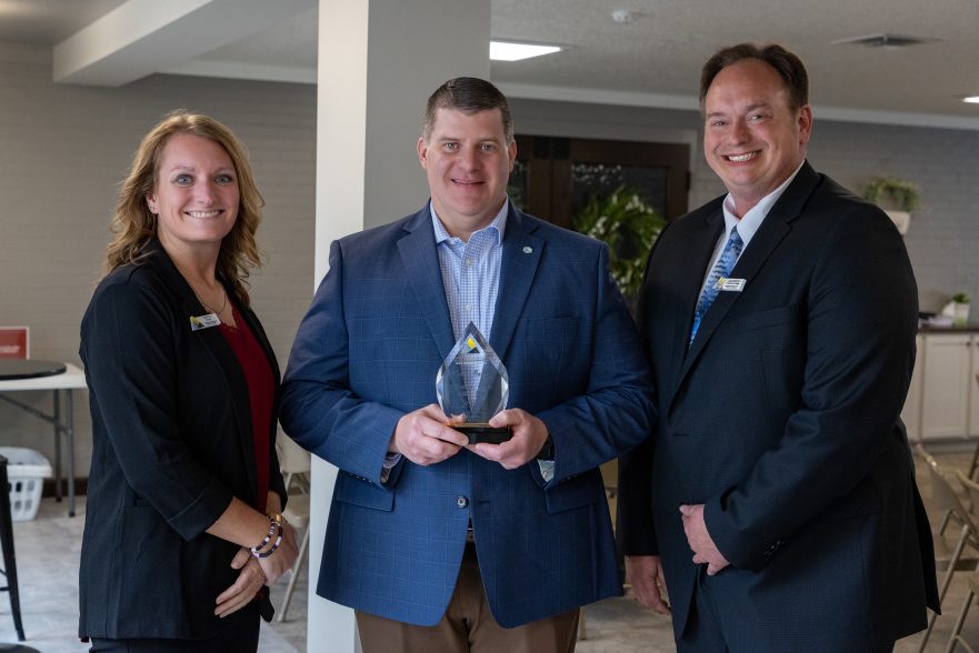 Garmann Miller CEO Eric Baltzell holding award from Southwestern Auglaize County Chamber