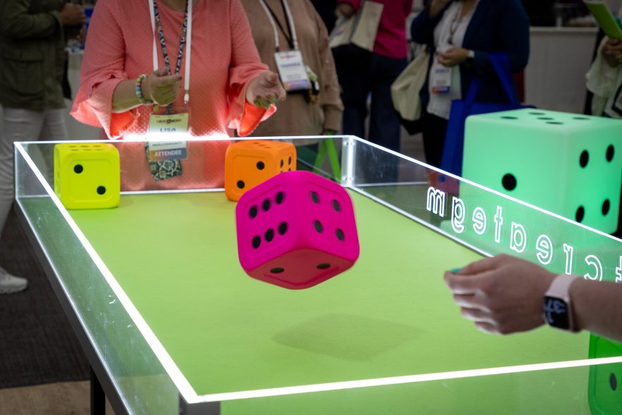 Garmann Miller team at trade show with dice game